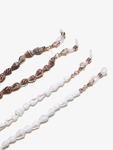 Detail of natural conch shell eyewear chains with anti-slip silicone loops and metal clasps