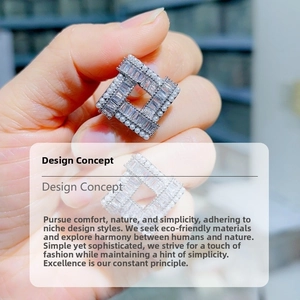 Detail view of geometric silver earrings with emerald-cut cubic zirconia and small pearls