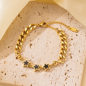 Detalle de la pulsera bañada en oro de 18 quilates con cadena cubana, serpiente y estrellas