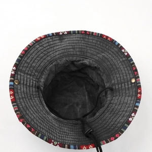 Detail of embroidered ethnic trim on washed cotton sun hat with adjustable chin strap