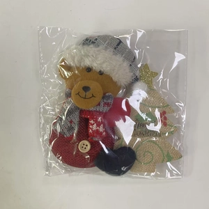 Dettaglio di albero di Natale in peluche con orsetto marrone e testo Merry Christmas stampato