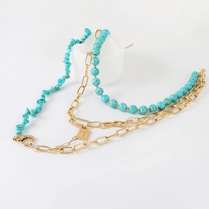 Bohemian multilayer necklace with turquoise beads and gold metal chain on white background