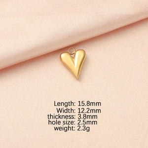 Macro view of gold heart pendant with detailed dimensions 15.8mm on peach fabric
