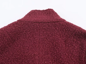 Macro shot of burgundy wool boucle fabric texture on a stylish French vintage coat