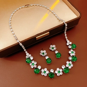 Detailed view of emerald green zircon flower jewelry set on leather background