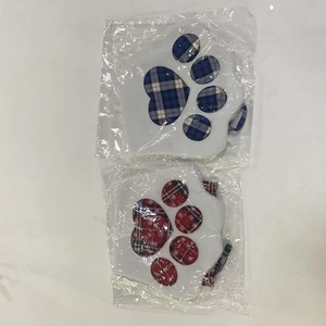 Detail view of two plush pet Christmas stockings in dog paw shapes with plaid patterns