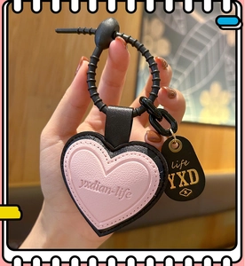 Detail of pink and black heart leather keychain with gold engraving and rubber loop