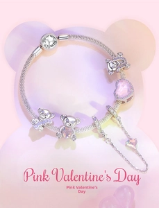 Detalle de dijes de oso y colgante de corazón rosa en pulsera con cierre Forever Family