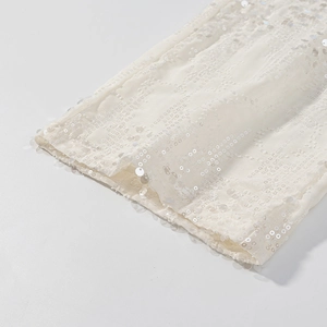 Dettaglio di paillettes di lusso su tessuto mesh per completo beige blazer e pantaloni