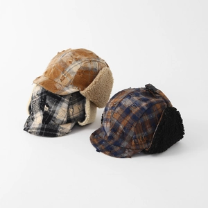 Detail view of winter plaid trapper hats with warm fleece lining and buckle strap