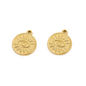 Macro shot of two golden evil eye pendants with embossed circular relief design