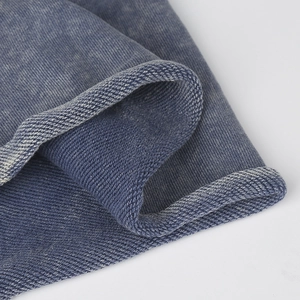 Close-up of blue washed cotton fabric with detailed curling edge stitching and texture