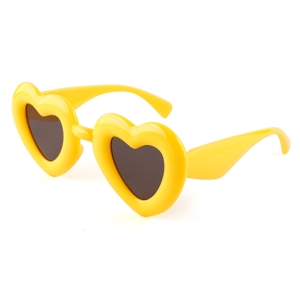 Fashionable yellow heart-shaped sunglasses with dark lenses shown from a 45-degree angle
