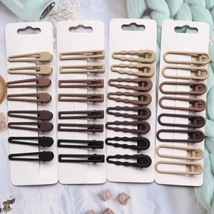 Close-up of matte brown hair clips set in various geometric shapes on a card