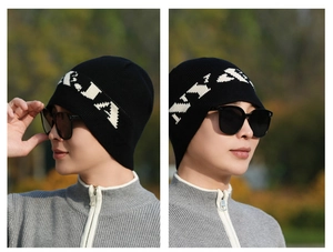 Close-up of black knit beanie featuring white NY embroidery and textured wool pattern