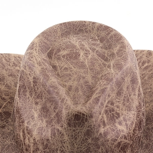 Close-up of vintage brown cracked leather texture on a western cowboy jazz hat