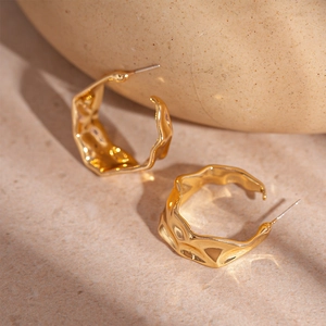 Minimalist gold twisted C-shape hoop earrings with fluid liquid metal wavy texture