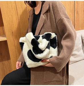 Close-up of fluffy cow print plush tote bag with soft faux fur texture and handle detail