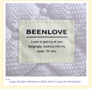 Detail of white embossed fabric texture and stitched brand label on cosmetic bag