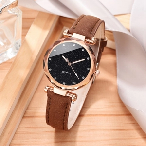 Women's starry sky quartz watch with rose gold case and brown leather band on wood base