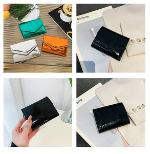 Detail view of metallic envelope wallets in green, silver, orange, and black colors