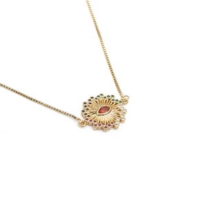 Collier doré avec pendentif œil maléfique et zircons multicolores sur fond blanc