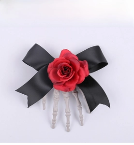 Detail of gothic Halloween hair clip with red rose, black bow and skeleton hand
