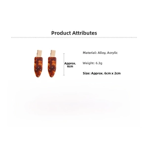 Detail view of acrylic amber hair clip with alloy accents showing 6cm length and colorful dots