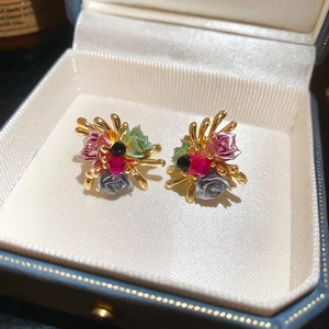 Macro shot of colorful 3D rose flower earrings with gemstones in a gift box