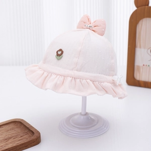 Detail of pink baby sun hat with floral embroidery and polka dot bow on stand