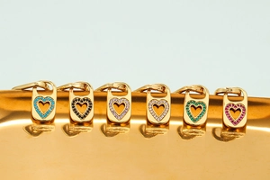 Detail of six heart-shaped gold metal pendants with colorful zircon stone inlays