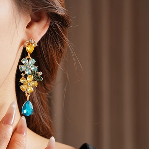 Close-up of vintage floral tassel earrings with colorful crystals on model