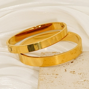 Minimalist 18K gold plated stainless steel bangles set on premium textured stone