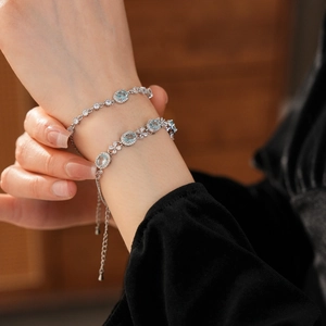 Close-up of silver-tone bracelets featuring light blue oval stones and floral zircon details