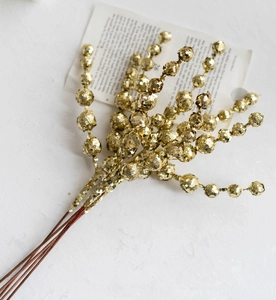 Detailed view of glittering golden berry branch ornaments for Christmas tree decoration