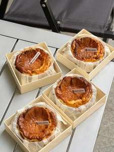 Macro shot of Basque cheesecake in premium disposable square packaging boxes
