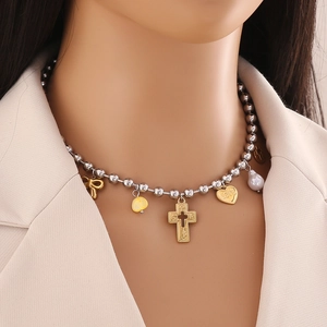 Silver bead necklace with gold bow, cross, love heart, and pearl charms on model