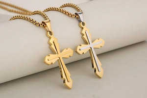 Detailed shot of gold and silver layered cross pendants on stainless steel chains