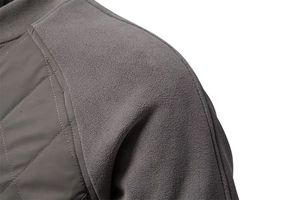 Macro detail of men's quilted jacket featuring raglan fleece sleeves and ribbed collar