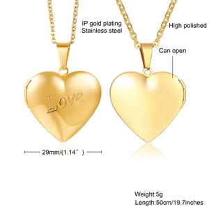 Macro detail of high polished gold heart locket with Love engraving and open design