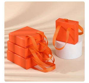 Detail of orange drawer jewelry gift box featuring a woven silk ribbon handle puller