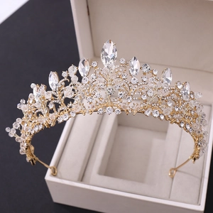 Macro view of bridal tiara with gold frame and sparkling crystals in a gift box