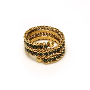 Macro detail of 18k gold triple layered spiral ring with emerald green square zirconia