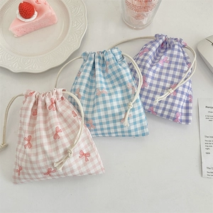 Three plaid drawstring fabric pouches in pink, blue, and purple with bow details
