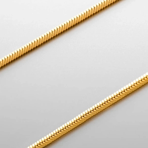 Detailed close-up of golden flat snake bone chain showing metallic texture and sleek finish