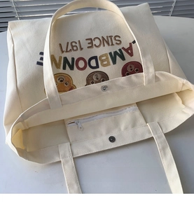 Detail of canvas tote bag showing magnetic snap closure and interior zippered pocket