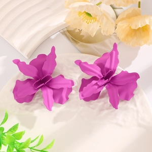 Macro detail of large matte purple flower earrings with textured geometric petals
