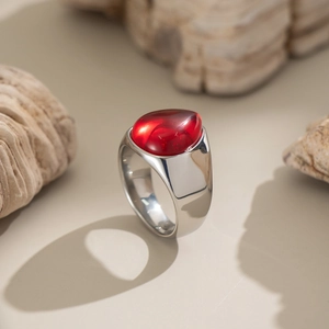 Gros plan détaillé d'une bague en argent avec pierre naturelle rouge ovale sur roche
