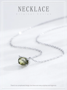 Detail of S925 silver necklace with olive green oval stone and cat ear design