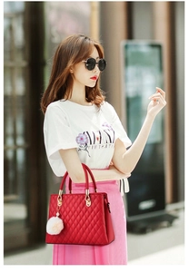 Elegant red quilted handbag with white faux fur charm shown in a lifestyle street view